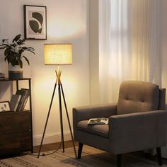 a living room with a chair, lamp and pictures on the wall