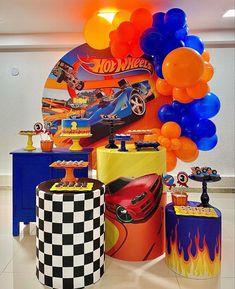 a room filled with balloons and cars on top of a white floor next to a blue table