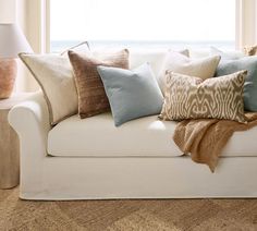 a white couch with many pillows on it