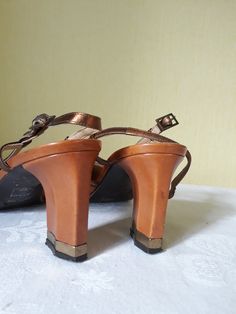 "Vtg tawny, tan brown (with bronze straps) leather women leather slingback shoes. Summer shoes with the 90s square toes and angular block heels (gold color bottoms). EU size 37. Made in Italy. Comfy footwear.European quality. condition: normal condition. A little used, some signs of wear. Shabby bottom soles. Heels height 8,2 cm / 3.2\" in approx. outsole length- 27,4 cm / 10.7\" in size: EU 37 - labeled size; US 6.5" Retro Brown Heels With Block Heel, Brown Leather Block Heel Slingback Sandals, Vintage Leather Block Heels, Brown Sandals With Heel Strap And Square Toe, Brown Square Toe Sandals With Heel Strap, Vintage Sandals With Padded Block Heel, Vintage Brown Heels With Heel Strap, Vintage Heels With Padded Heel And Square Toe, Vintage Square Toe Heels For Party