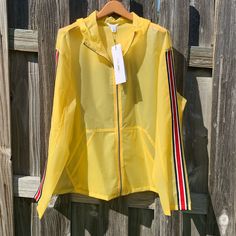 Calvin Klein Hooded Rain Coat In Bright Yellow With Contrasting Red, White And Blue Striping Down Sleeves. Two Pockets At Waist. Jacket Is Rain Resistant. Polyurethane. Wipe Clean. Nwt Xxl Casual Yellow Hooded Jacket For Spring, Spring Hooded Stretch Track Jacket, Spring Stretch Hooded Track Jacket, Sporty Calvin Klein Fall Outerwear, Calvin Klein Casual Spring Outerwear, Spring Outerwear With Stretch And Double-lined Hood, Yellow Hooded Color Block Outerwear, Calvin Klein Sporty Long Sleeve Outerwear, Yellow Hooded Sporty Windbreaker