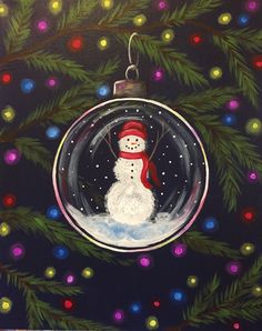 a snowman ornament hanging from a christmas tree