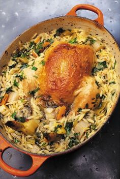 a close up of a chicken in a pot filled with pasta and veggies