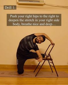 a man standing on top of a wooden chair with his hand on the back of it