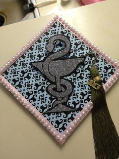 a decorated graduation cap with a tassel hanging from it's side on a table