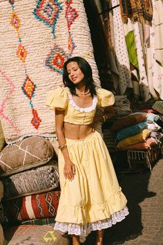 This yellow skirt exudes timeless beauty, with its middle front button adding texture and visual interest. Bottom is adorned with delicate ruffles and embroidered lace. It fits snugly at the waist before flowing gracefully down, creating a stunning and feminine silhouette suitable for any occasion.Composition: Shell: 100% cottonLining: 100% cotton Care Instructions: Cold Hand WashOr Dry Clean Yellow Crop Top, Yellow Skirt, Balloon Sleeves, Embroidered Lace, Skirts For Sale, Marrakech, In The Middle, Scoop Neckline, Timeless Beauty