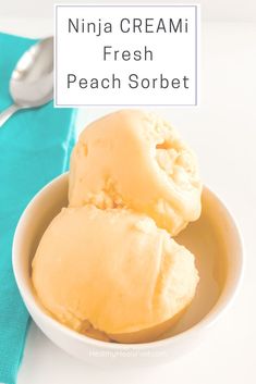 two scoops of fresh peach sorbet in a white bowl on a turquoise napkin