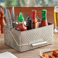 a metal container filled with lots of condiments next to a glass of beer