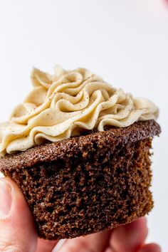 a hand holding up a chocolate cupcake with white frosting on top and the words gingerbread cupcakes above it