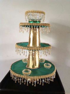 three tiered cake stand with green and gold decorations