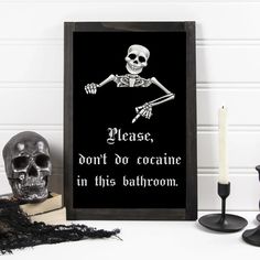 a black framed sign with a skeleton on it