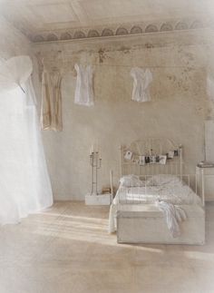 an old fashioned bedroom with clothes hanging on the wall