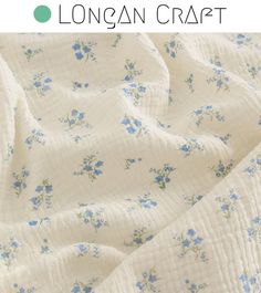 a white quilt with blue flowers on it and the words longan craft written in green