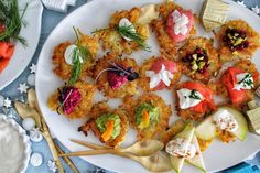 an assortment of appetizers on a plate with spoons and utensils