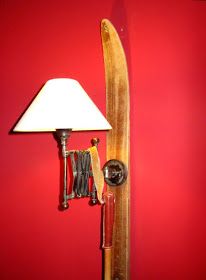 a surfboard mounted to the side of a red wall with a lamp on it