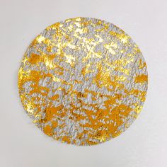 a round gold and silver plate with white speckles on the surface, against a white background