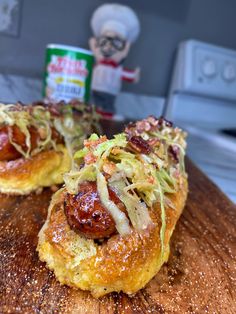 two hotdogs with toppings on a wooden cutting board