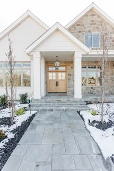 the front entrance to a home with snow on the ground