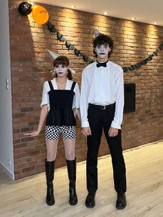 two people in costumes standing next to each other on a hard wood floored room