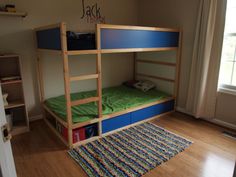 there is a bunk bed with green sheets and blue drawers in the room that has a rug on the floor next to it