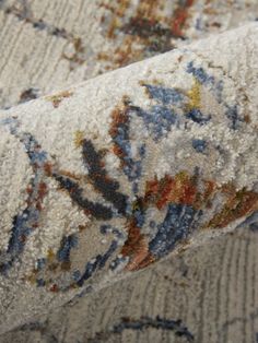 an area rug with various colors and designs on it's surface, close up