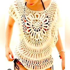 a woman wearing a white crochet top and black shorts with her hand in her pocket