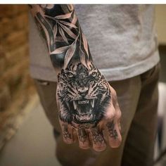 a man's hand with a tiger tattoo on it