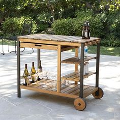 an outdoor bar cart with bottles and glasses on it