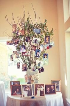 a vase filled with flowers and pictures on top of a table next to a window