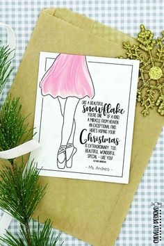 a christmas card with a drawing of a woman in a pink dress on top of a brown envelope