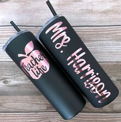 two black tumblers with pink lettering and an apple on the front one says make her happy