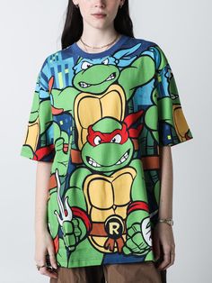 a woman wearing a t - shirt with an image of teenage mutant turtles on it