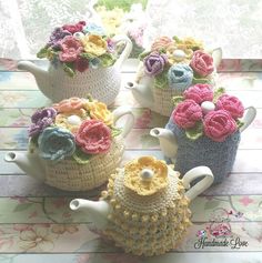 four crocheted teapots with flowers on them