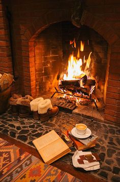 there is a fire in the fireplace with bread and coffee