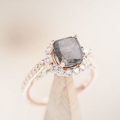 a ring with a large gray diamond surrounded by small white and clear diamonds on top