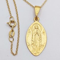 "This delicate medal of Our Lady of the Rosary has such fine detail and is 18K gold vermeil. The halo over the head of the Blessed Mother has the words \"Je suis l'Immaculée Conception\" as she told Bernadette Subiroux in Lourdes that she was the Immaculate Conception. The reverse of the medal has the  image of Our Lady of Lourdes. The medal measures 16x28mm without the bail. The medal hangs from an 18 inch Italian 18K gold vermeil chain. A beautiful treasure for someone who loves the Blessed Mo Gold Locket Necklace For Commemoration, Gold Charm Necklaces For Commemoration, Yellow Gold Oval Necklaces For Commemoration, Oval Yellow Gold Necklaces For Commemoration, Commemorative Oval Yellow Gold Necklace, 14k Gold Jewelry With Miraculous Medal, 14k Gold Miraculous Medal Jewelry In Gold, Commemoration Oval Yellow Gold Necklace, 14k Gold Necklace With Miraculous Medal