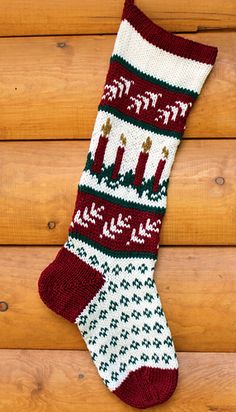 a green and white knitted christmas stocking with reindeers on it's side