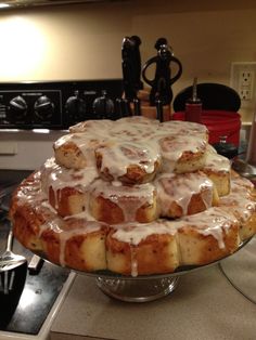 a cake sitting on top of a metal pan covered in icing next to a stove