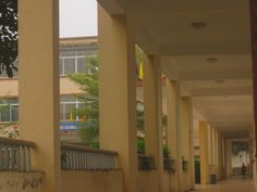 an empty hallway between two buildings with people walking on the sidewalk