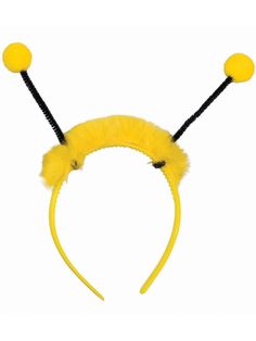 a yellow headband with two black pins and fuzzy balls on the top of it