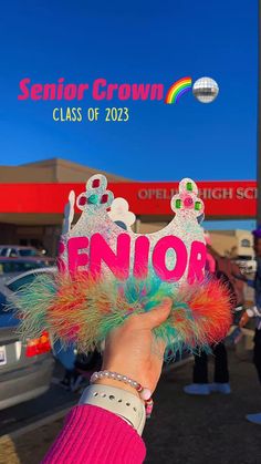 a person holds up a sign that says senior on it in front of a car dealership