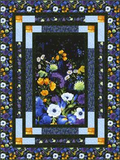 a blue and yellow quilt with flowers in the center on it's border is shown