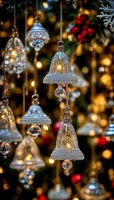 christmas ornaments hanging from the ceiling in front of a tree with lights and snowflakes