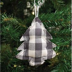 a plaid christmas tree ornament hanging from a pine tree with white and black flannel