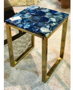 a blue and white table sitting on top of a carpeted floor next to a chair