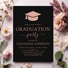 the graduation party is set up with pink flowers and greenery, along with a black card