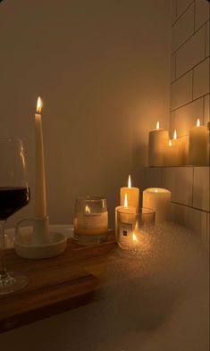 candles are lit next to a glass of wine