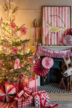 a decorated christmas tree in front of a fireplace with red and white decorations on it