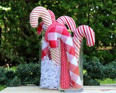 some candy canes are in a glass vase