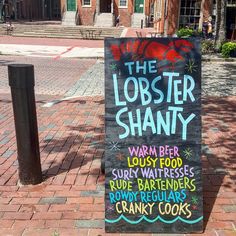 a sign advertising the lobster shanty on a brick sidewalk